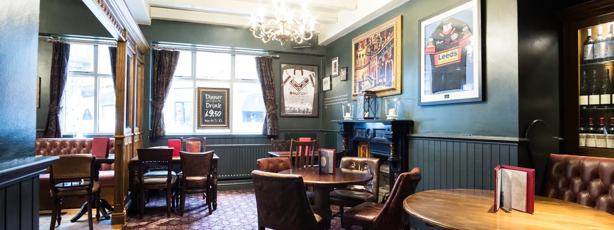 The Scarbrough Hotel — traditional pub interior with dark green walls, leather seating, and period chandelier