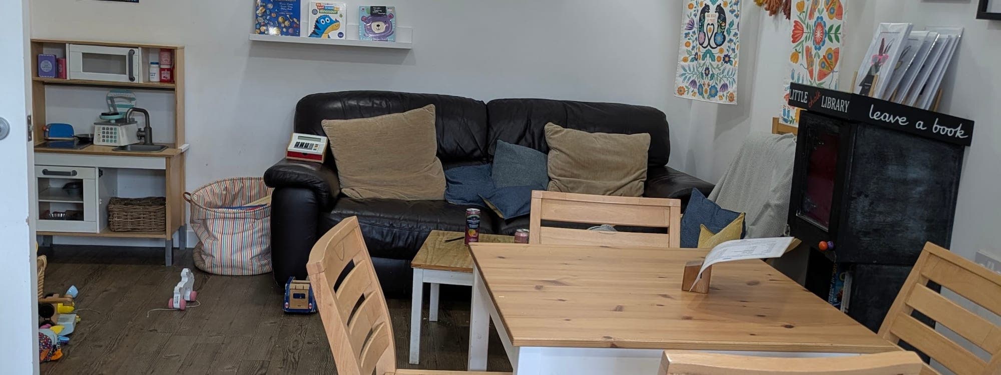 Interior of 21 Co. cafe in Headingley showing wooden tables, sofas, paper lanterns, and artwork