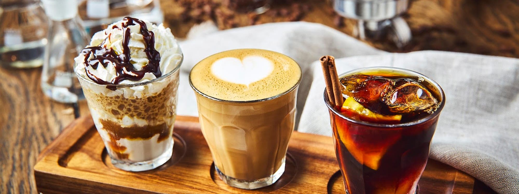 Coffee flight with mocha, latte art, and iced coffee on a wooden board at Caffeine Addict Headingley