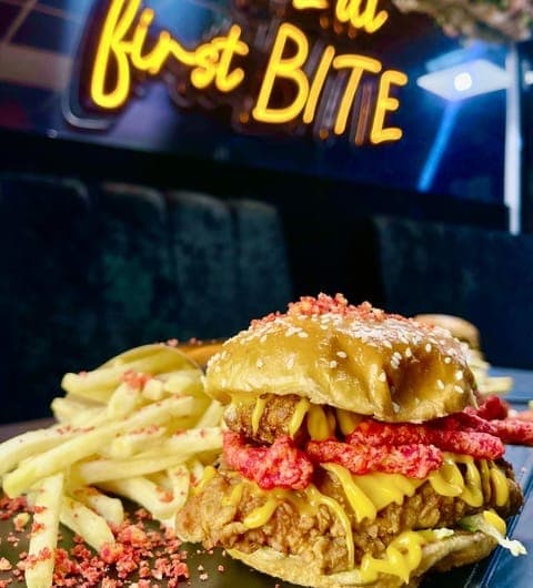 FiveStar burgers and shakes — loaded smash burger with fries and neon sign