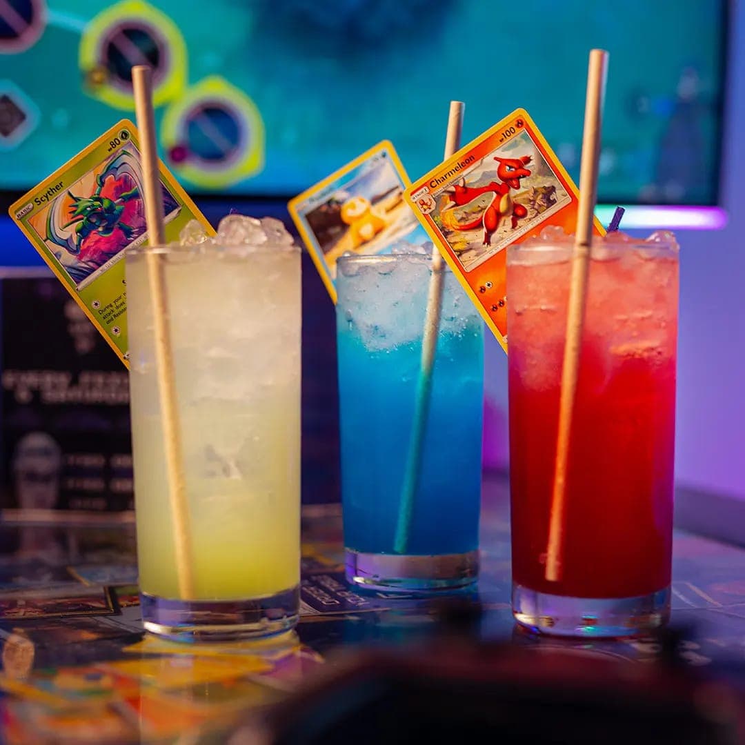 Three colourful Pokemon themed cocktails with trading cards at Pixel Bar Leeds