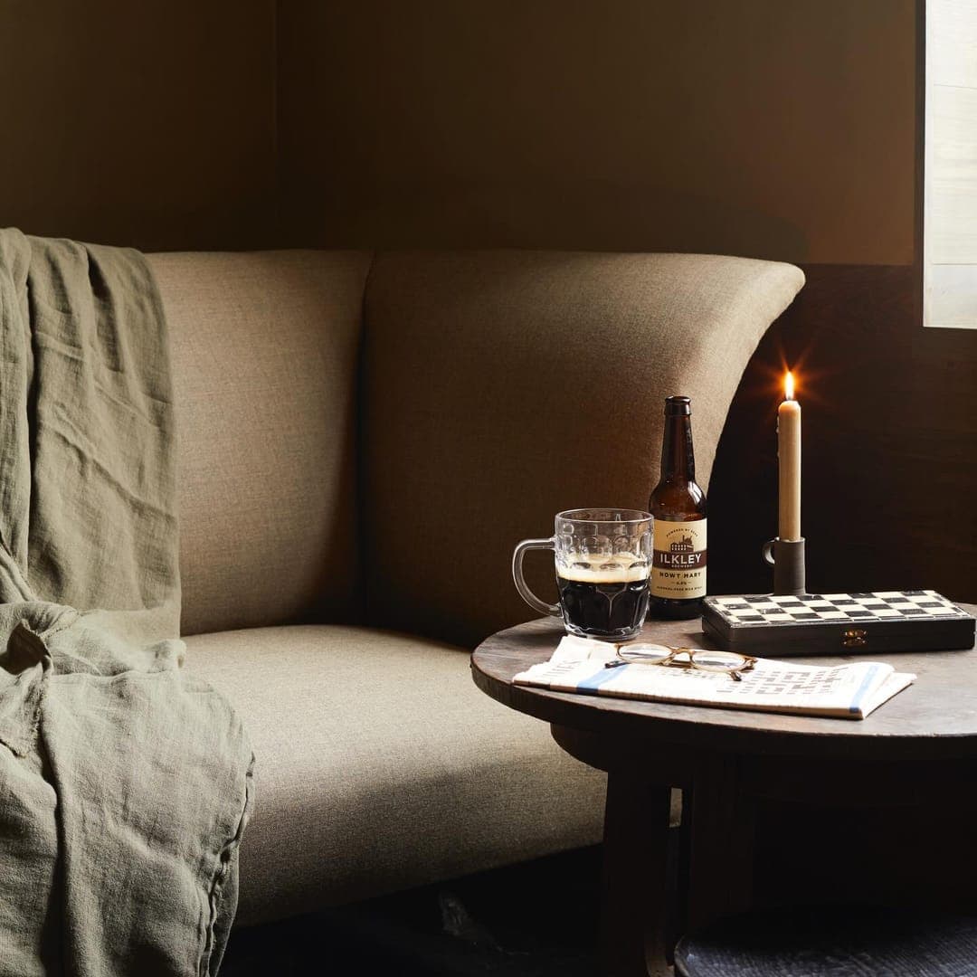 The Penny Bun — cosy interior with candle, throws and Ilkley beer