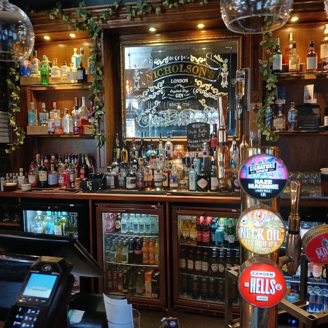 The Scarbrough Hotel — back bar display with Nicholsons mirror, spirits, and cask ale pump clips