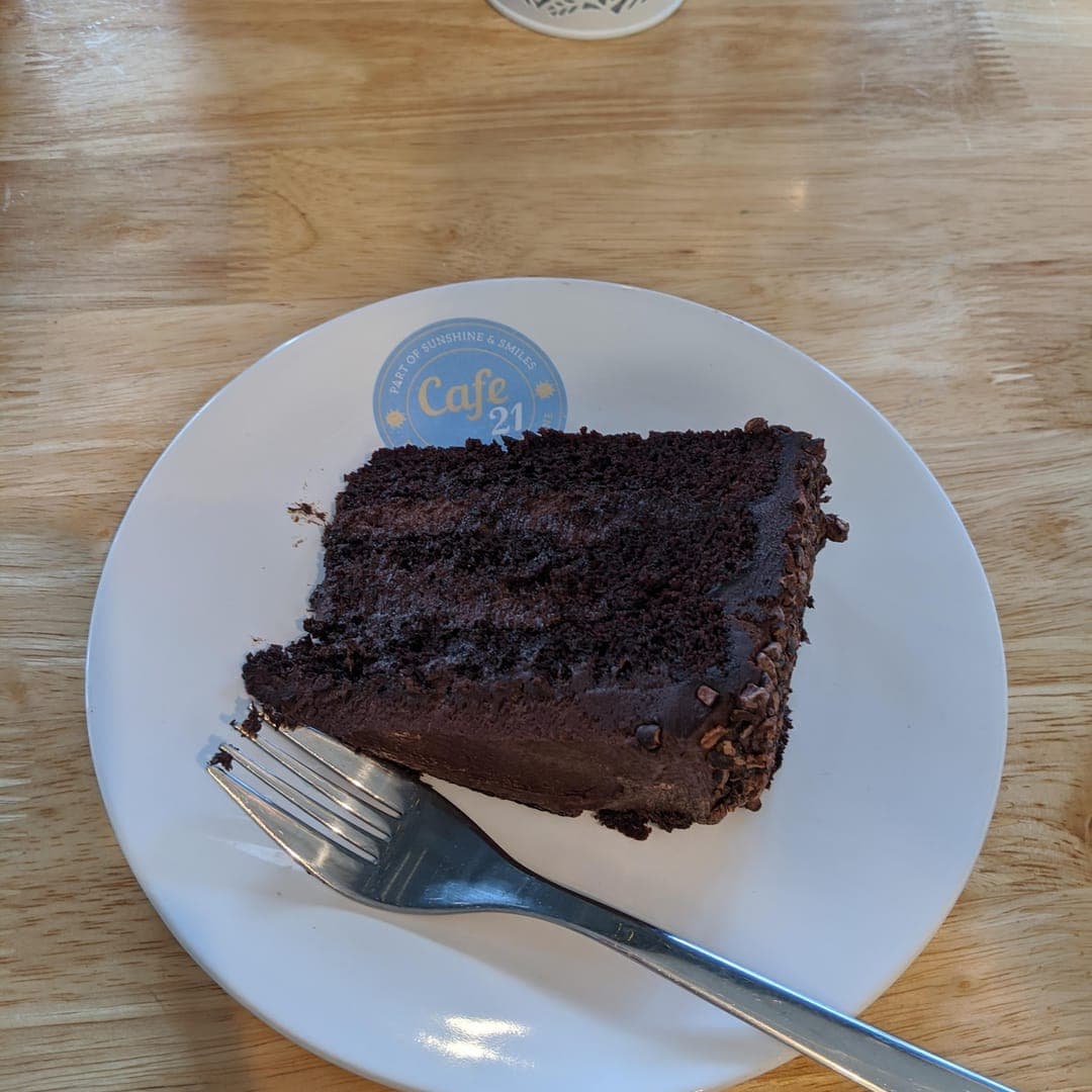 Chocolate cake slice on a Cafe 21 branded plate
