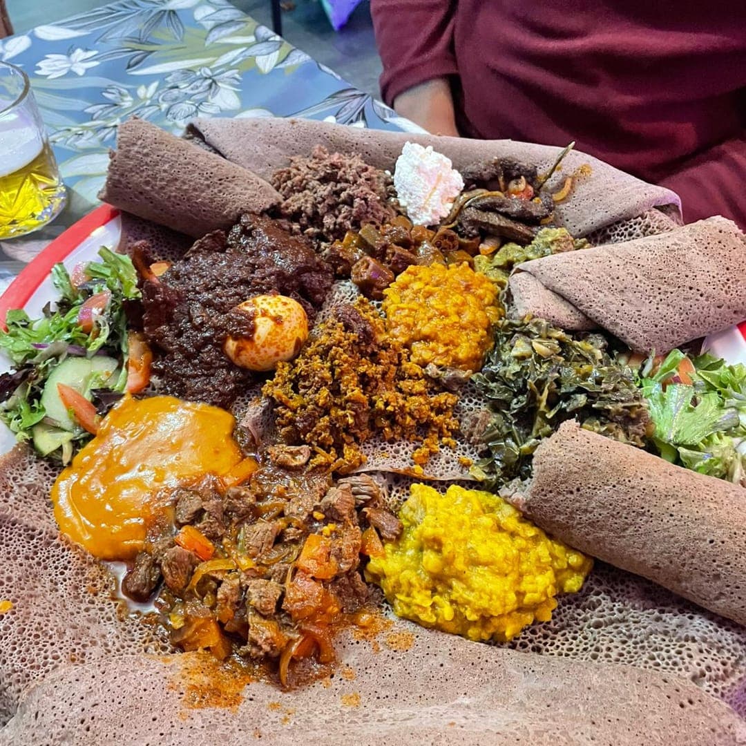 Colourful Ethiopian sharing platter with lentils, stews, and injera at Abashawel