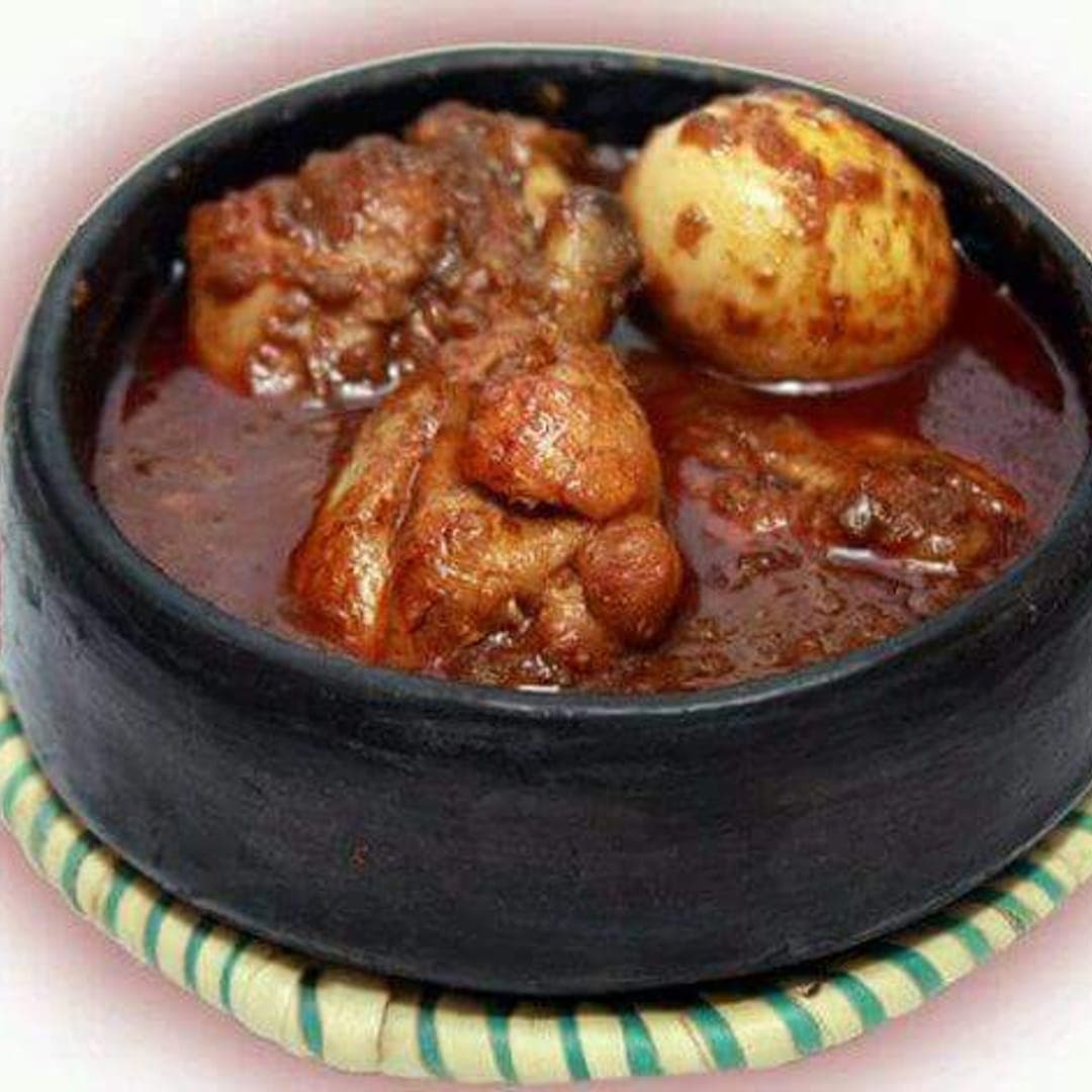 Traditional doro wat with egg in a black clay pot at Abashawel Leeds