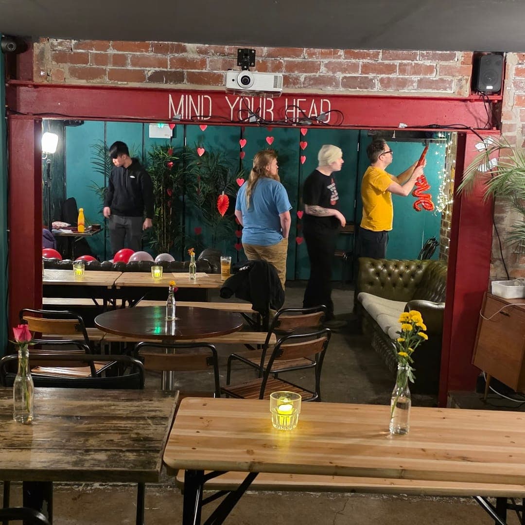 Interior of Boot and Rally with wooden tables, candles, and exposed brick walls
