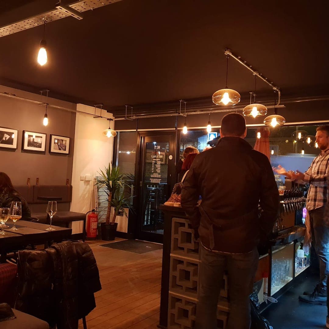 Bar area at Boot and Rally with industrial pendant lights and customers ordering