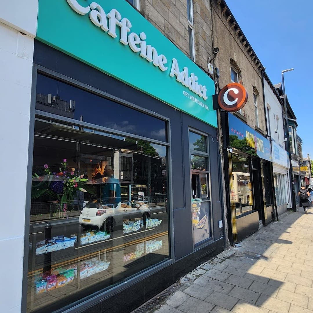 Exterior of Caffeine Addict cafe with teal signage on Otley Road Headingley Leeds