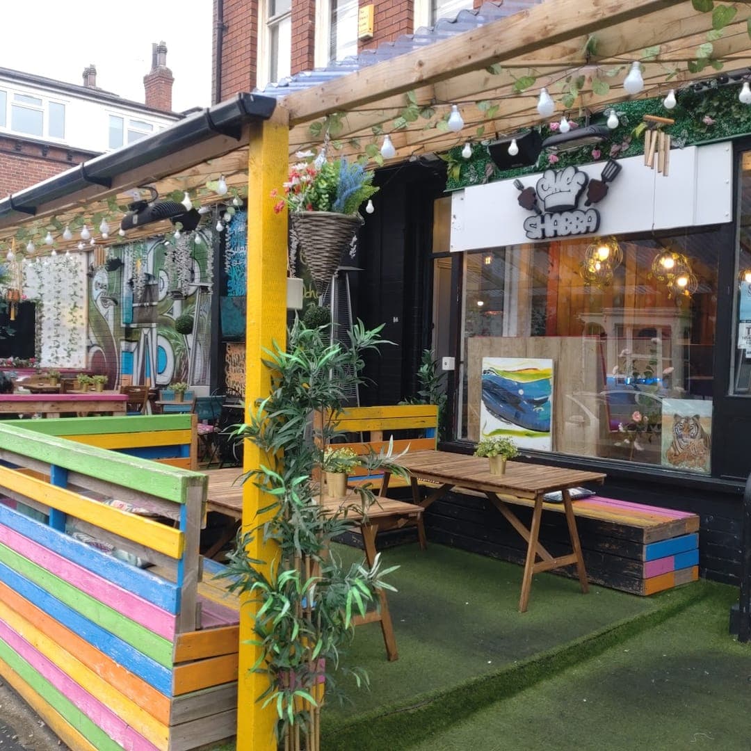 Exterior of Chef Shabbas with colourful pallet seating, fairy lights, and outdoor dining area