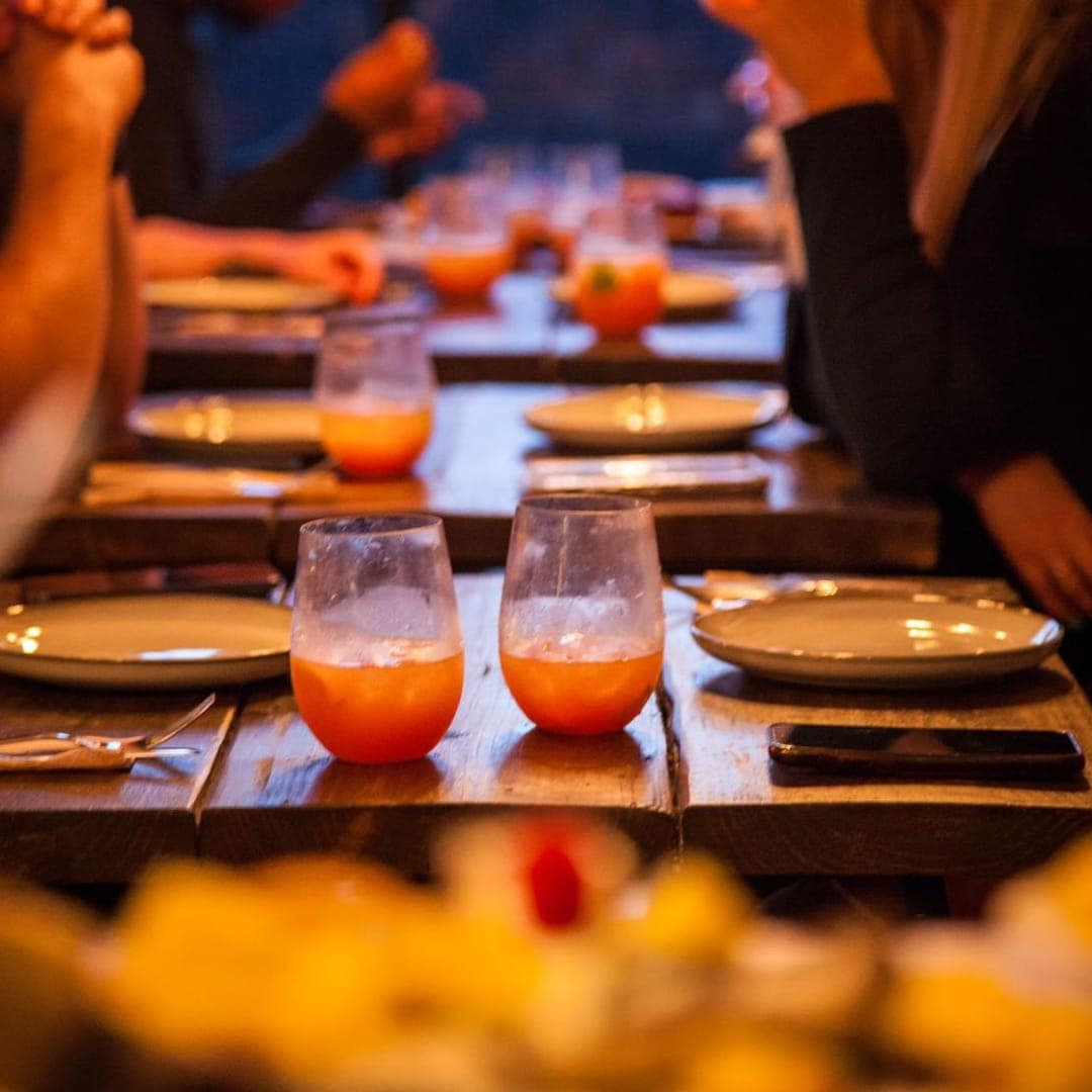 Atmospheric table setting with cocktails and place settings at Chef Shabbas Kitchen