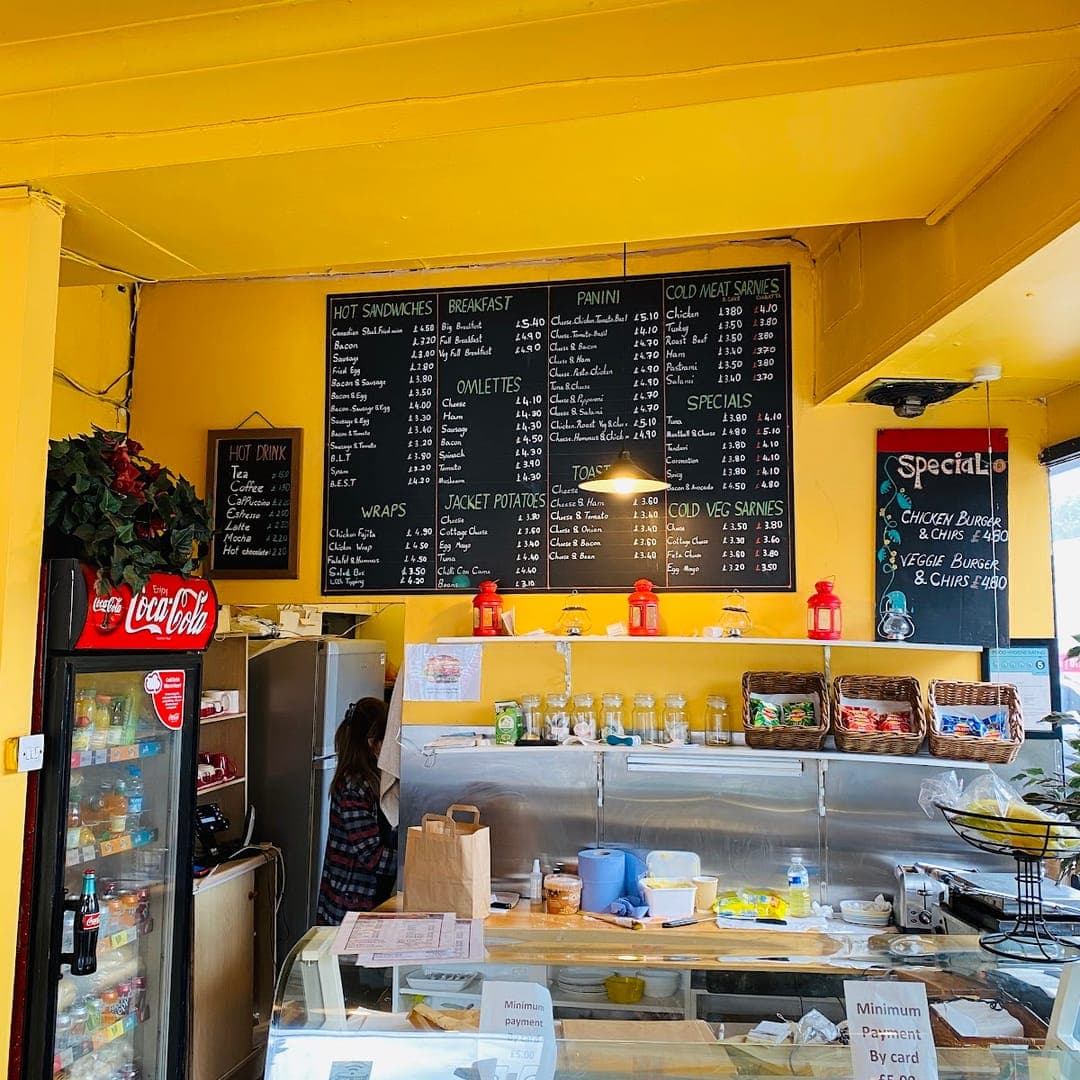 Counter area at Chichini with chalkboard menu, food display, and bright yellow decor