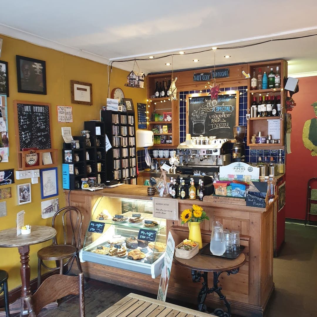 Counter area at Lento Cafe with cake display, chalkboard menus, and vintage decor