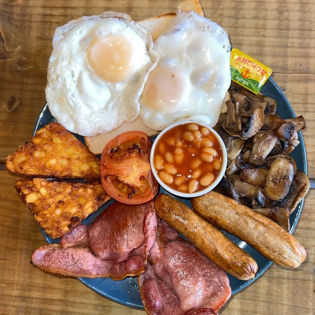 Full English breakfast with eggs, bacon, sausages, beans, and hash brown at Mistreci