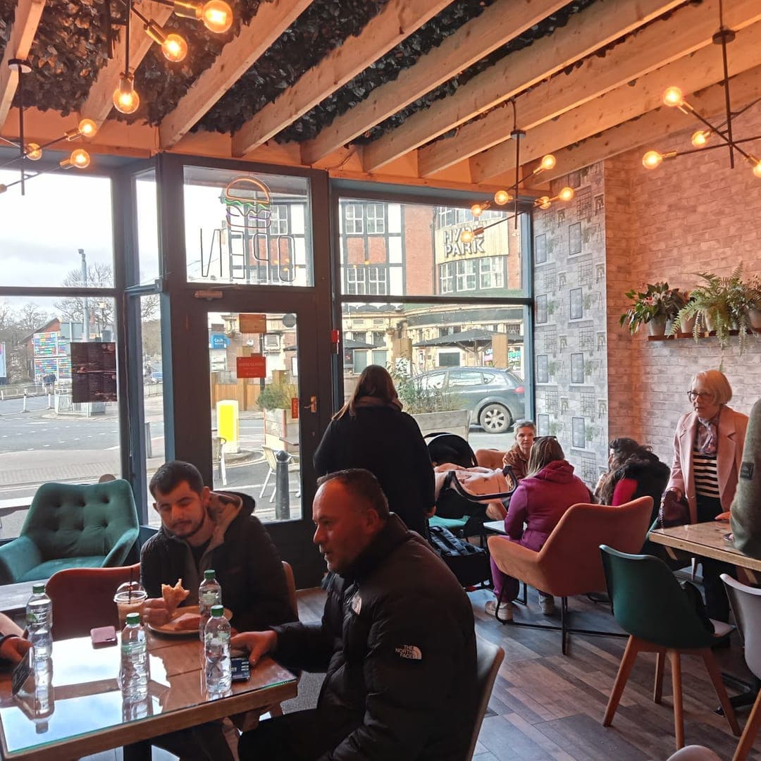 Busy interior of Mistreci cafe with fairy lights, brick walls, and customers dining