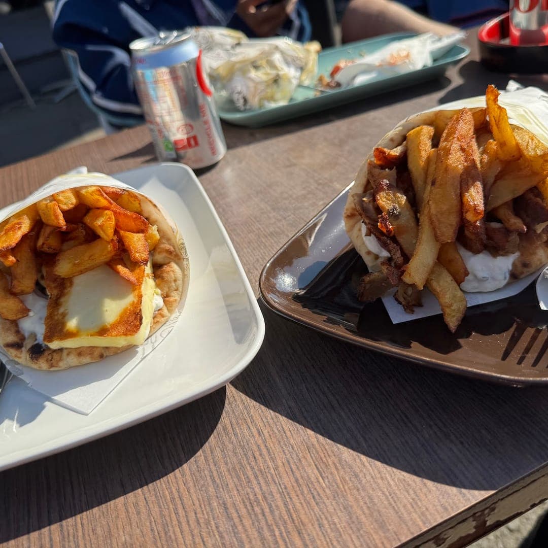Two loaded gyros wraps with fries on an outdoor table at Mistreci cafe