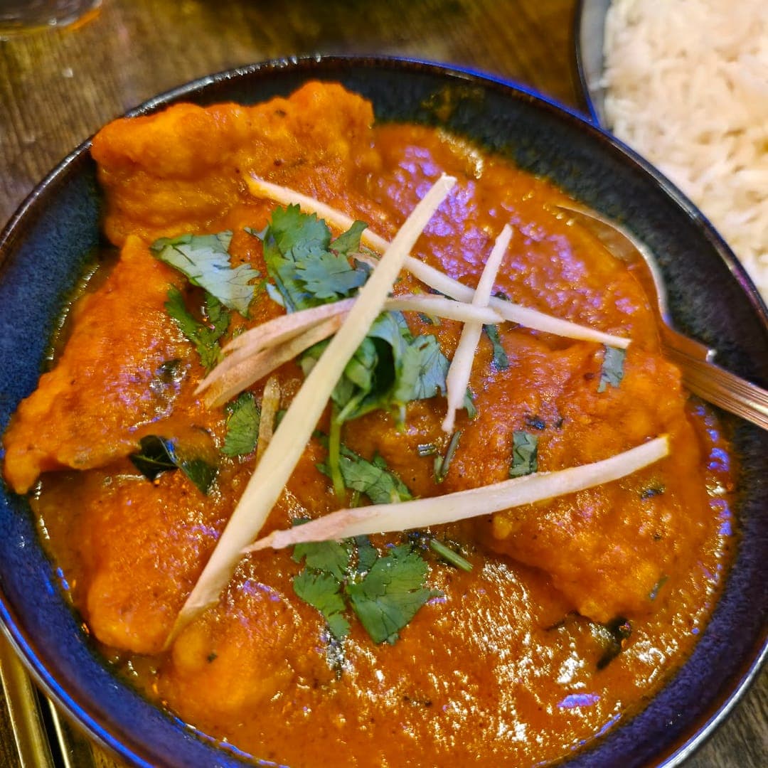 Rich chicken curry garnished with coriander and ginger at Mojo Royal Treat