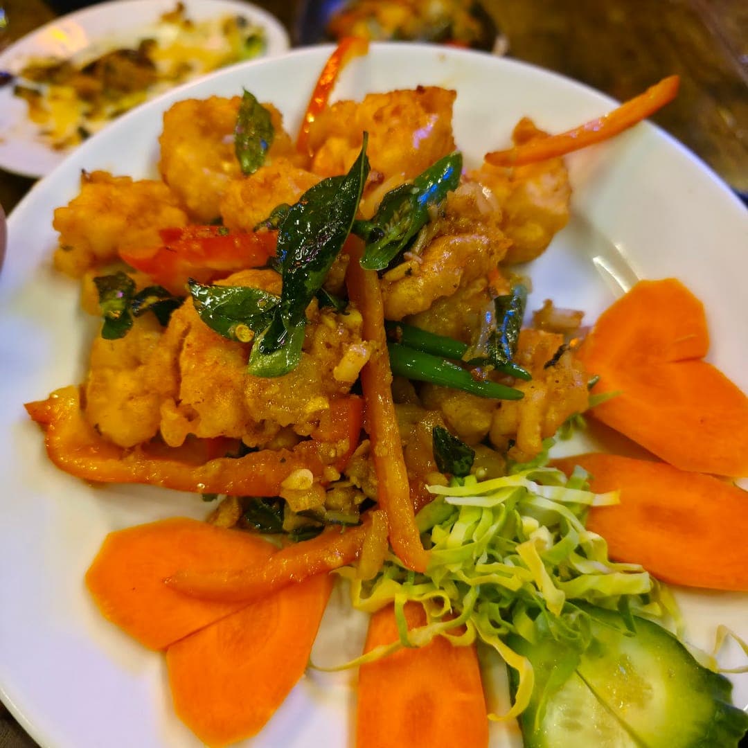 Crispy prawn dish with curry leaves, carrots, and fresh greens at Mojo Royal Treat