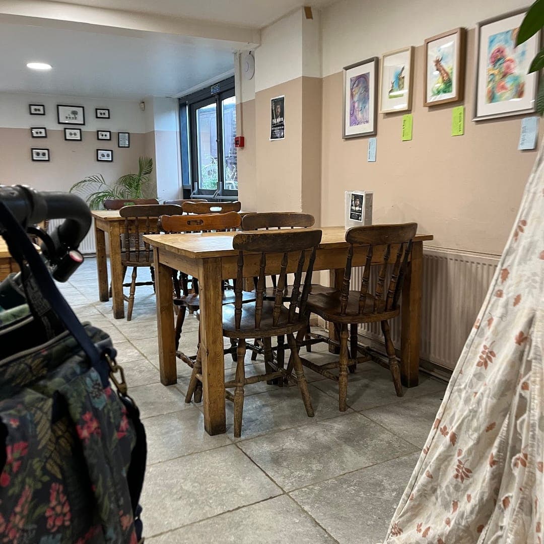 Interior seating area at The Barn with wooden tables, artwork, and family-friendly space
