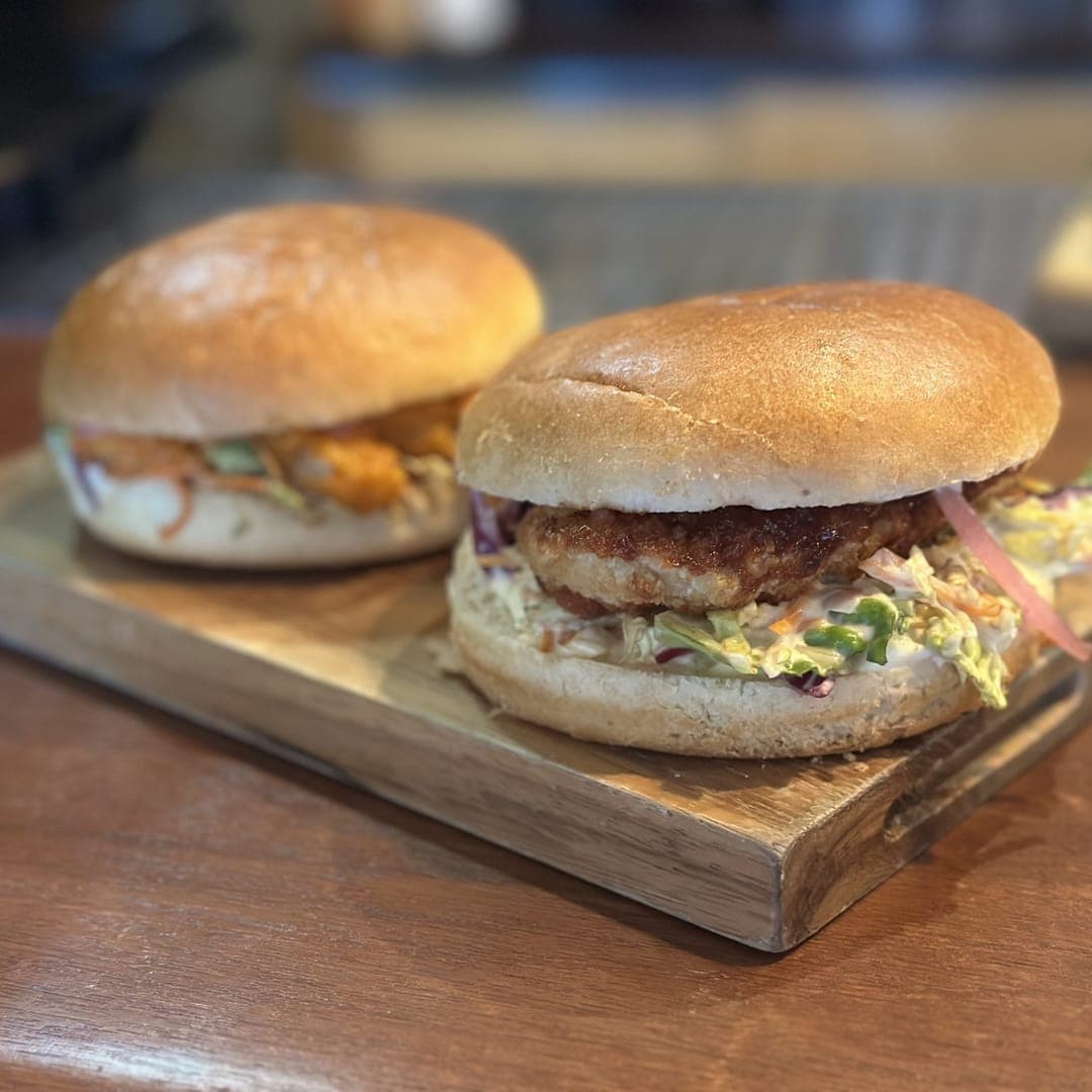 Grounded & Co — two loaded burgers on a wooden serving board