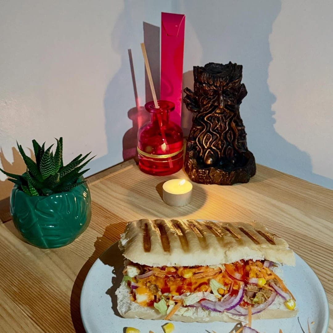 Munch Cafe English Kitchen — grilled panini sandwich on a plate with candle and decorative items