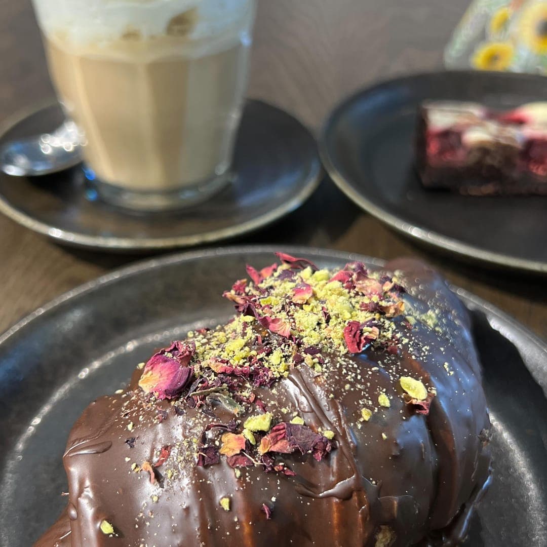 Munch Cafe English Kitchen — chocolate croissant pastry with rose petals and pistachio dust