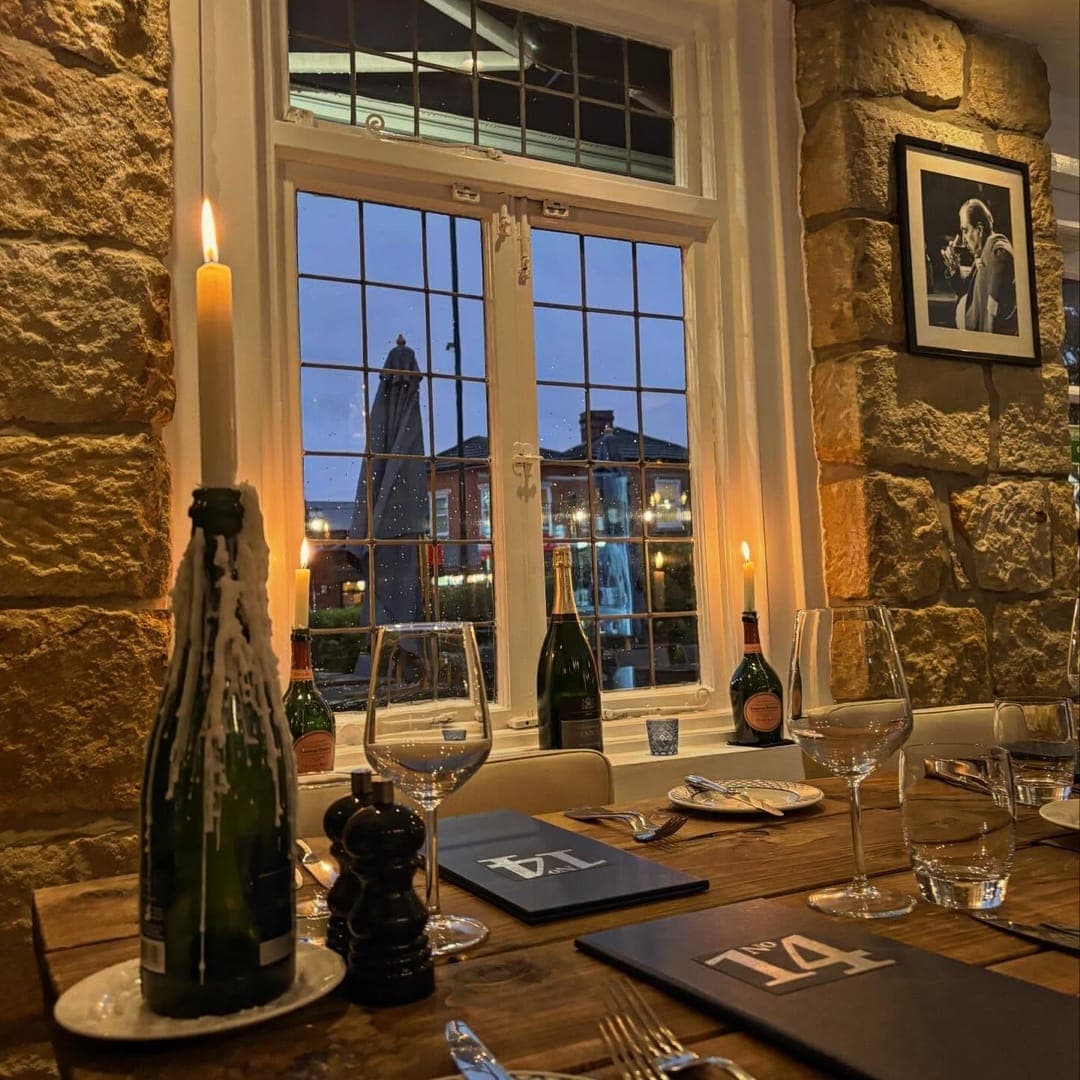 No 14 North Lane Restaurant & Bar — candlelit dining table set for dinner with stone walls and evening window view