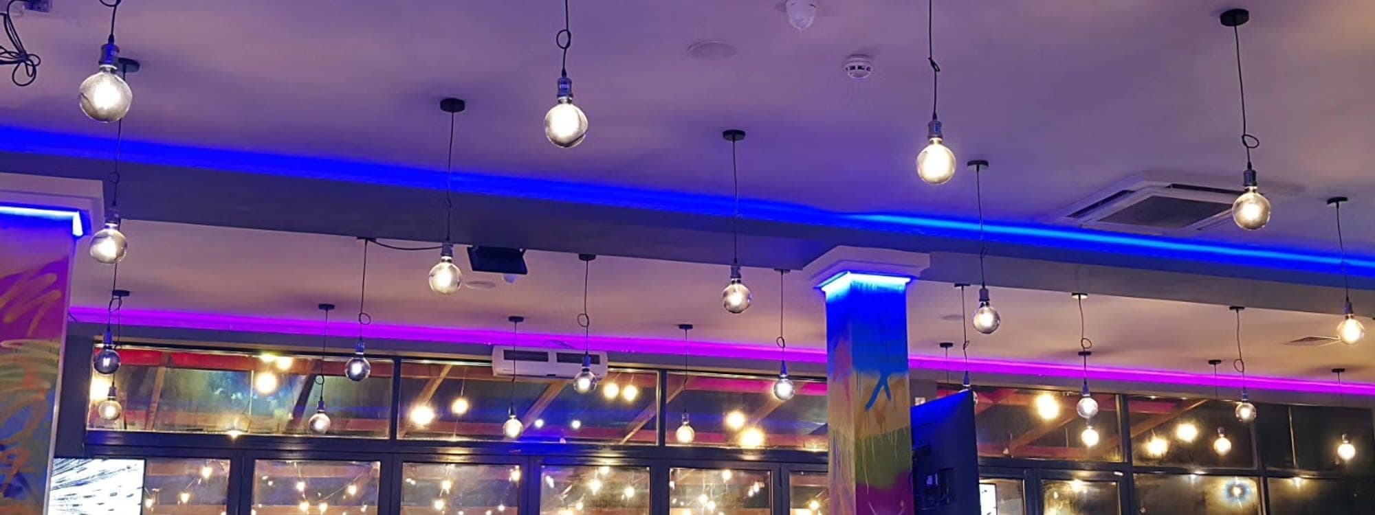 Panorama Garden — atmospheric interior with blue and purple LED lighting and pendant bulbs