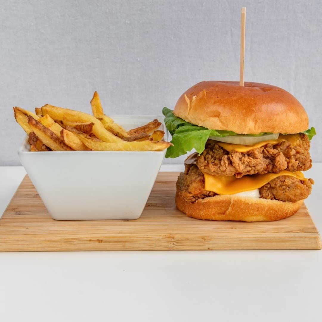 Panorama Garden — crispy fried chicken burger with cheese and fries on a wooden board