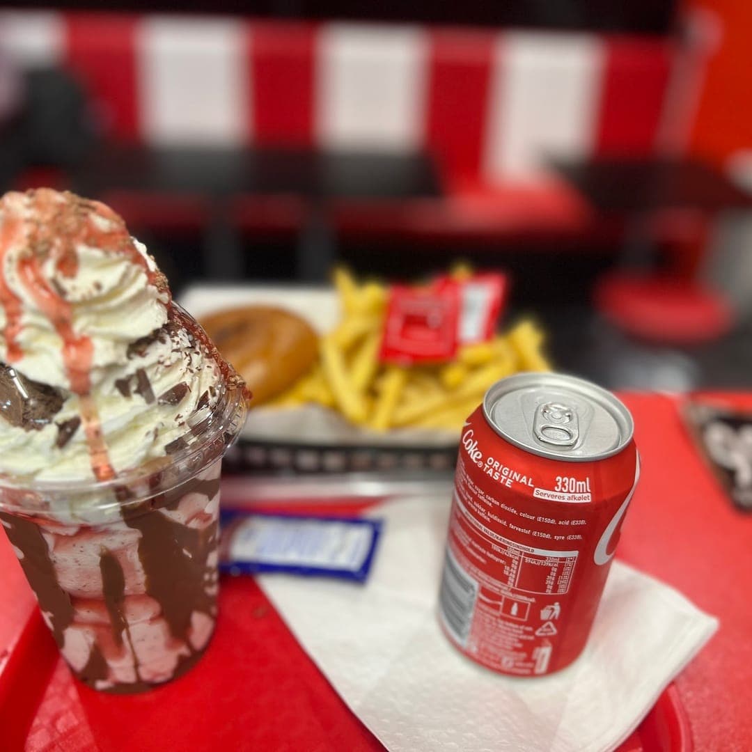 Route 66 — chocolate milkshake with cream, fries and burger on a red diner tray