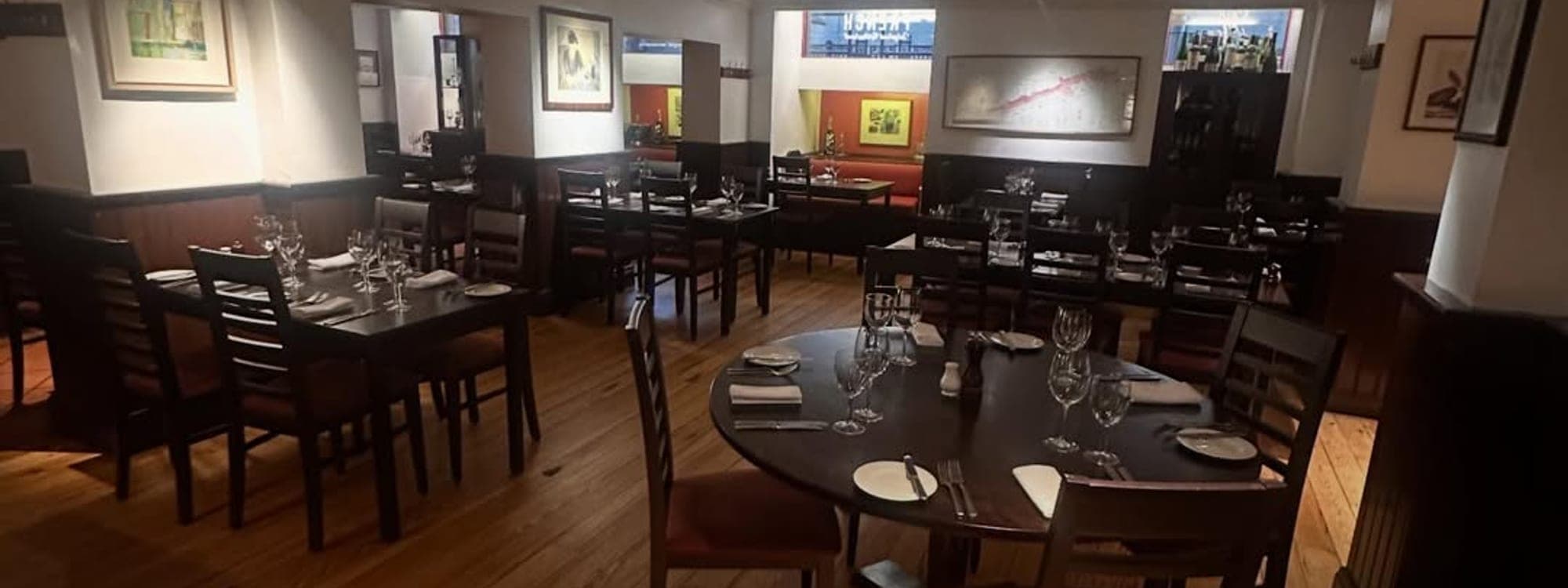Dining room at Sous Le Nez Leeds with warm wooden floors and set tables