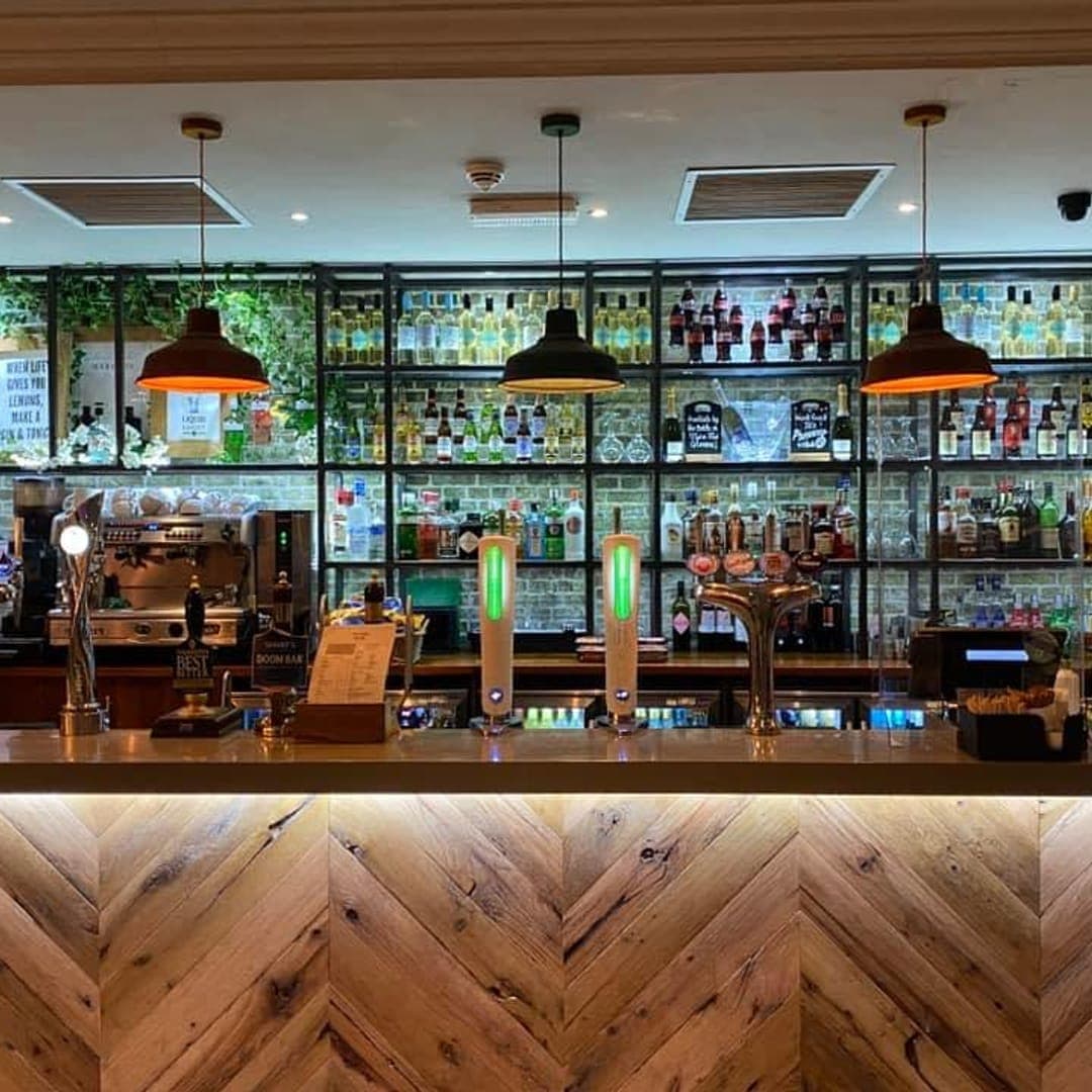The Beer House Leeds bar interior showing the full bar counter with real ale pumps and bottle shelving
