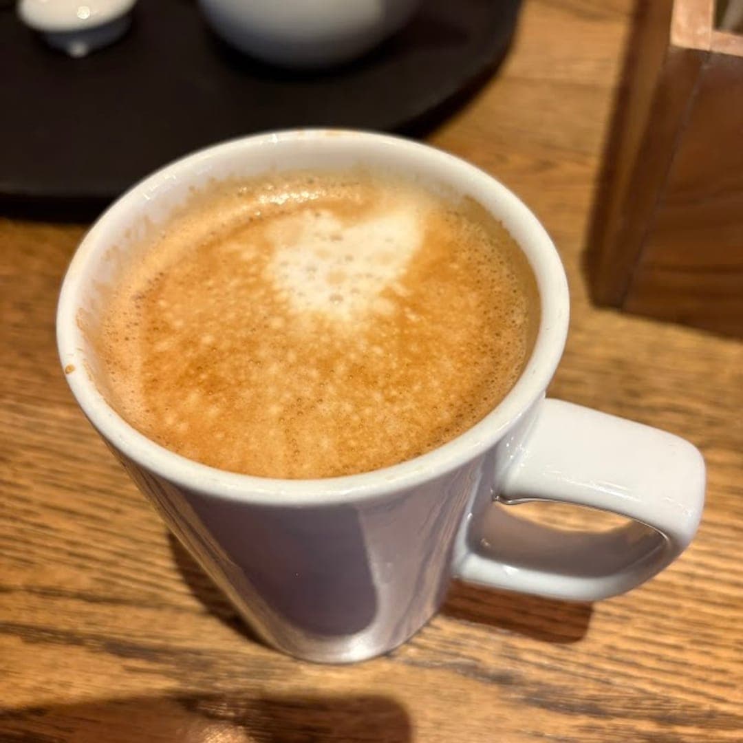 The Beer House Leeds coffee served in a white mug on a wooden table