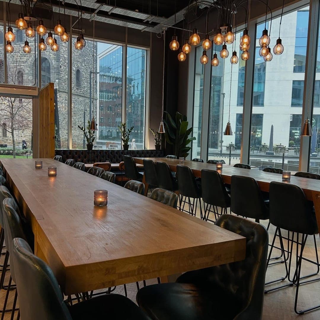 The Good Luck Club — dining room with industrial pendant lights and floor-to-ceiling windows