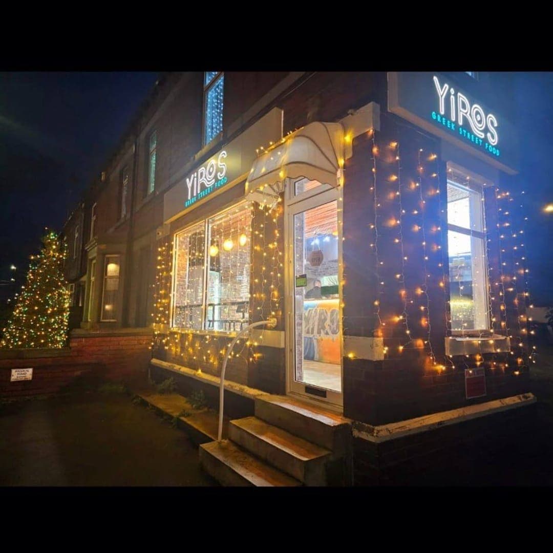 Yiros exterior at night showing illuminated signage, fairy lights and entrance steps on Aberford Road
