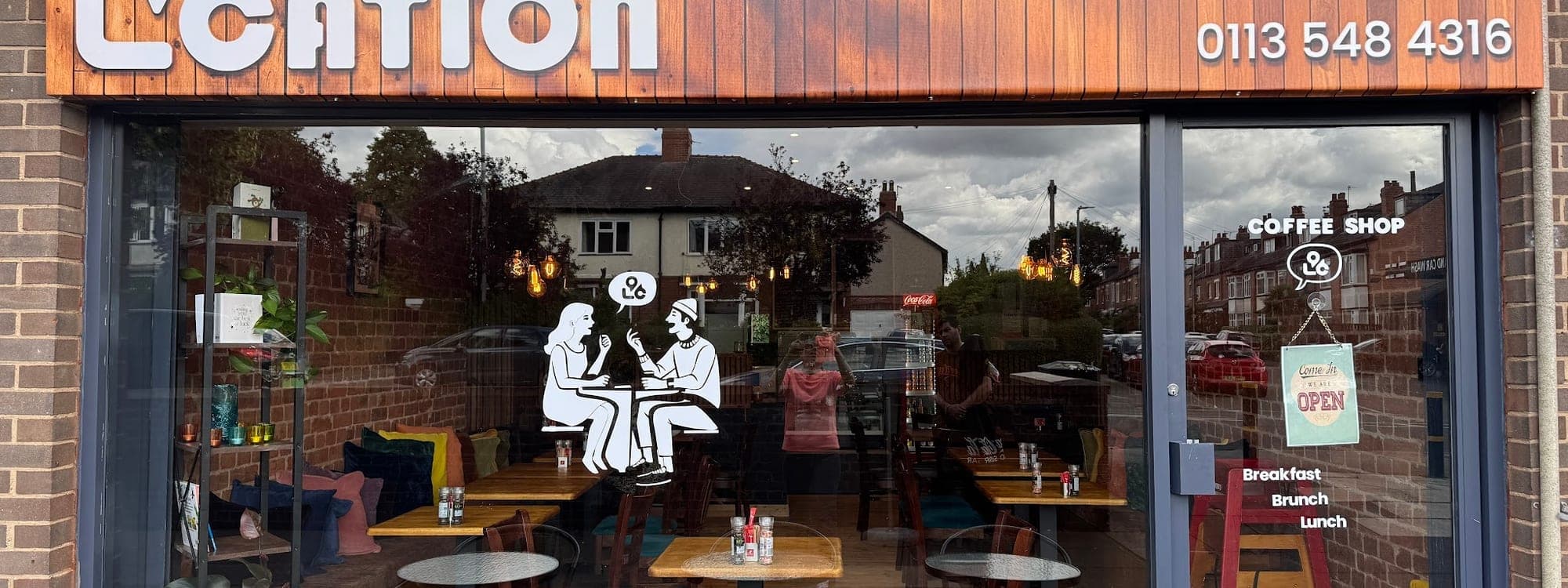 96 location Cafe — exterior frontage with outdoor seating and branded signage