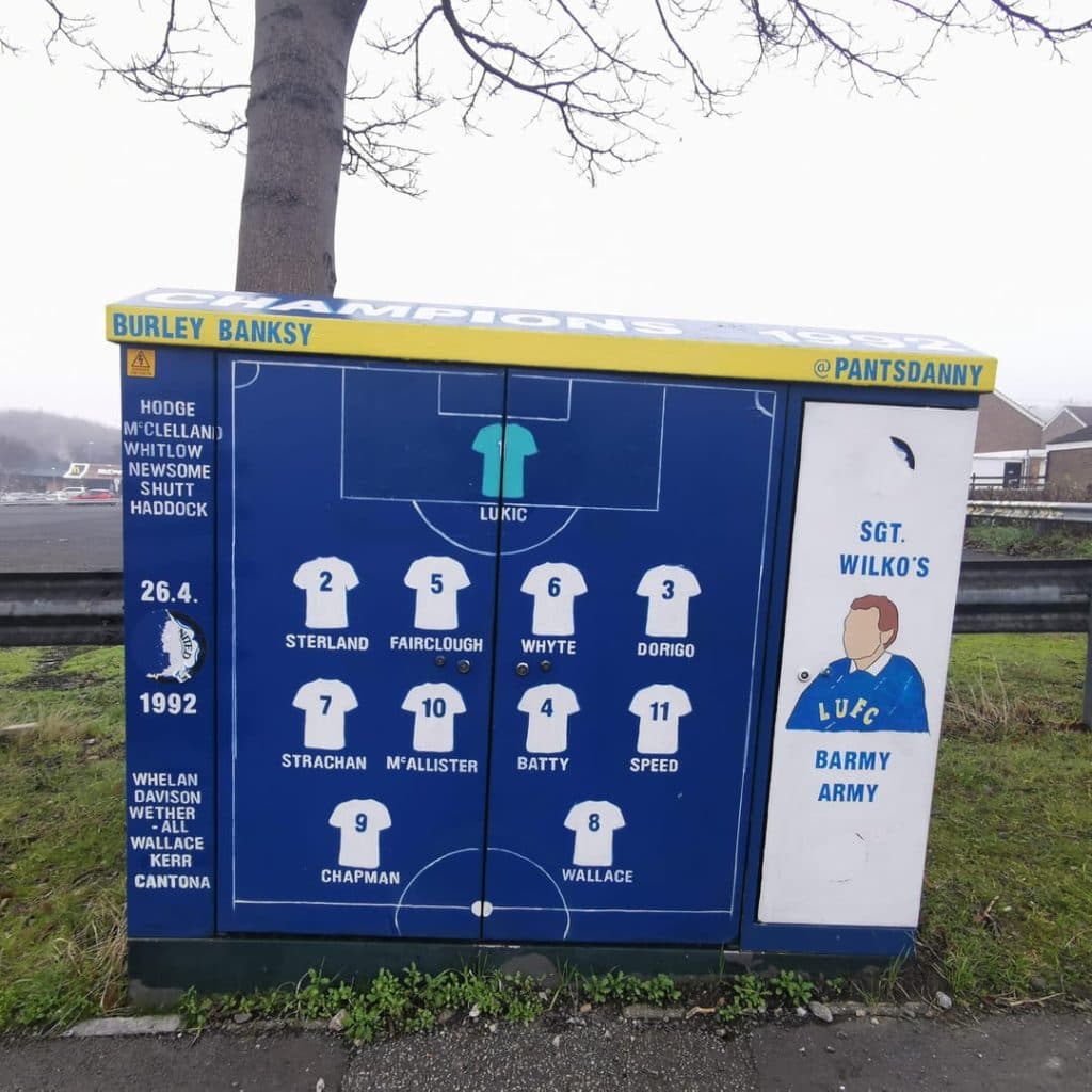 Burley Banksy painted box near Elland Road, Leeds — 1991-92 title-winning team line-up tribute on a utility cabinet, signed Burley Banksy and tagged @pantsdanny