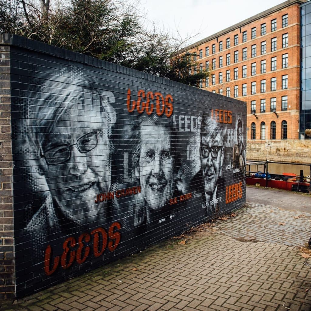 Faces of Leeds mural by Affix on Armouries Drive, Leeds — portraits of Alan Bennett, Sue Ryder, John Craven and Nicola Adams