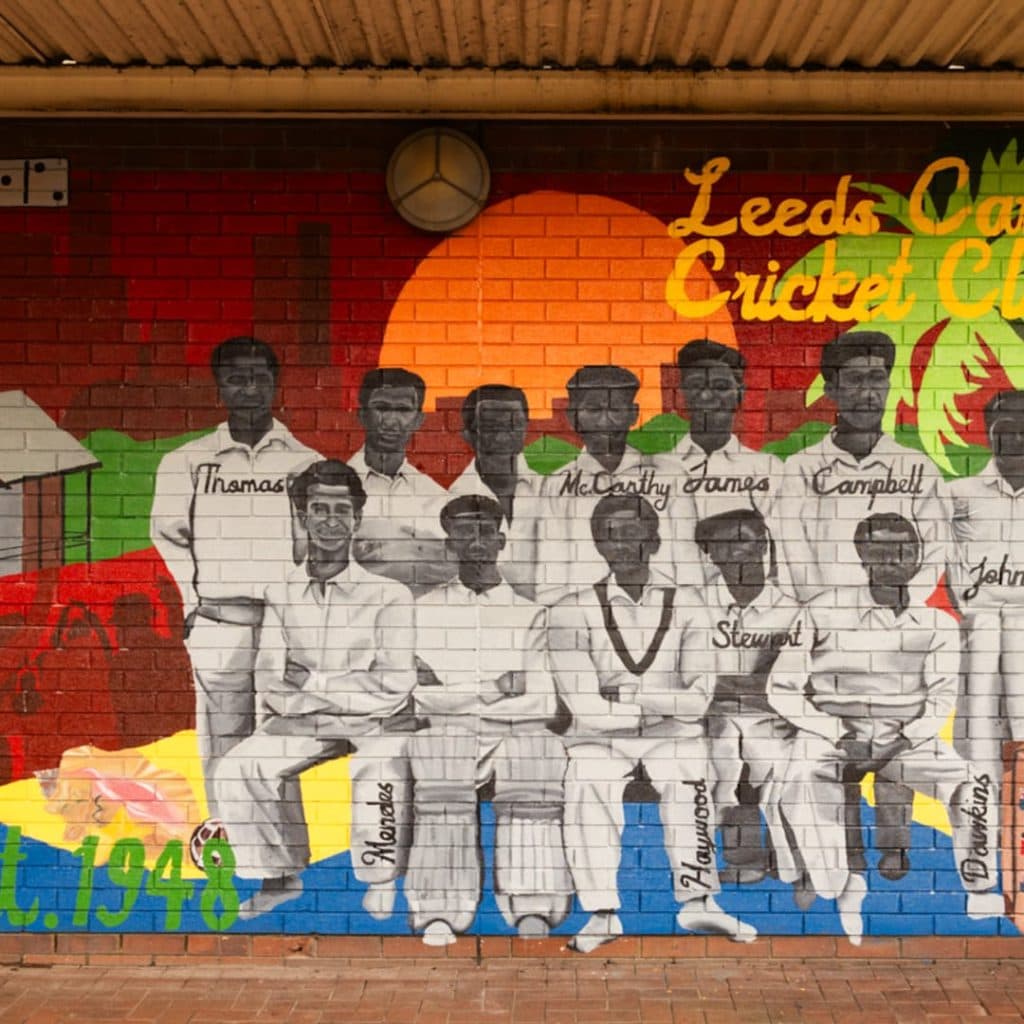 Leeds Caribbean Cricket Club mural by Jioni Warner inside Kirkgate Market, Leeds — historic team portrait with Caribbean colours and Est. 1948 banner