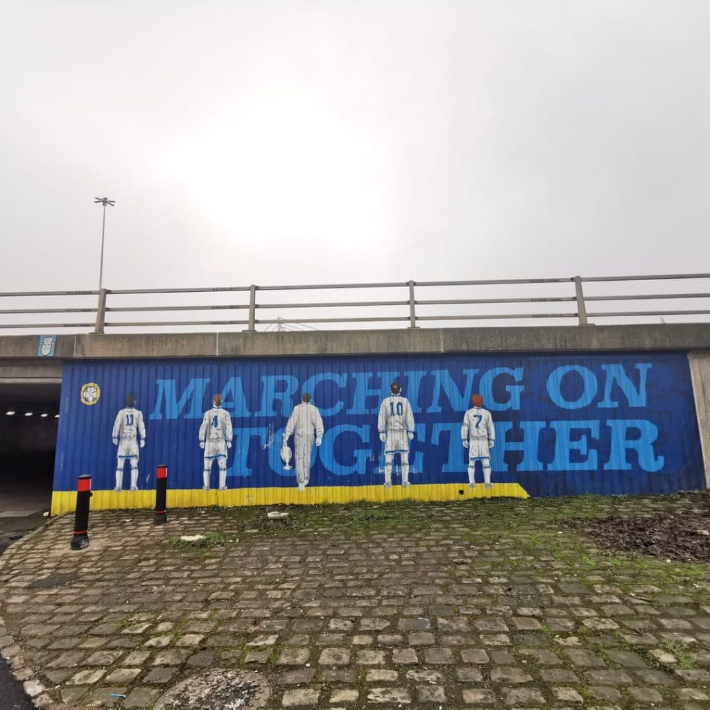 Marching on Together mural by Jameson Rogan in the Lowfields Road underpass, Leeds — backs of the 1991-92 title-winning midfield in white kit