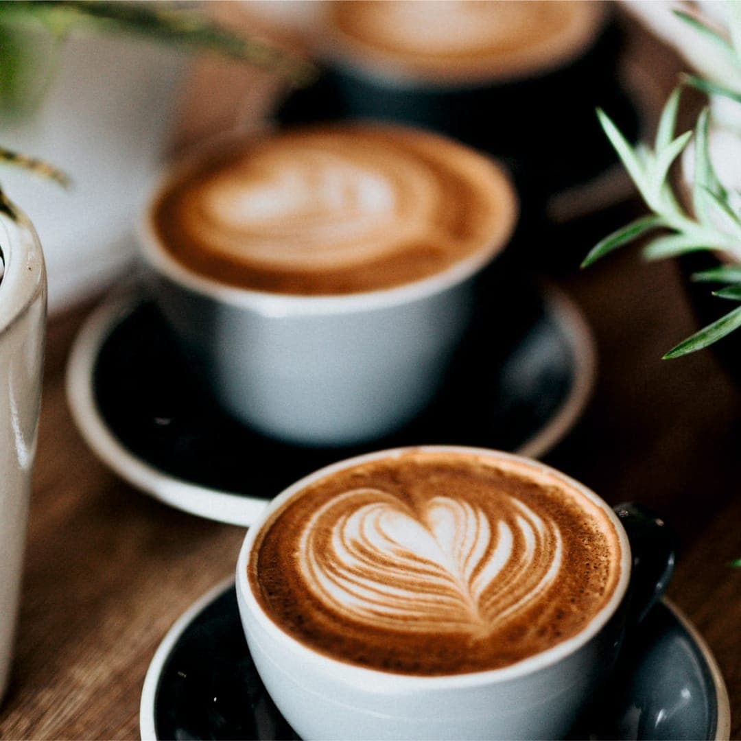 Flat white coffee with heart latte art in a white cup at Miracle cafe