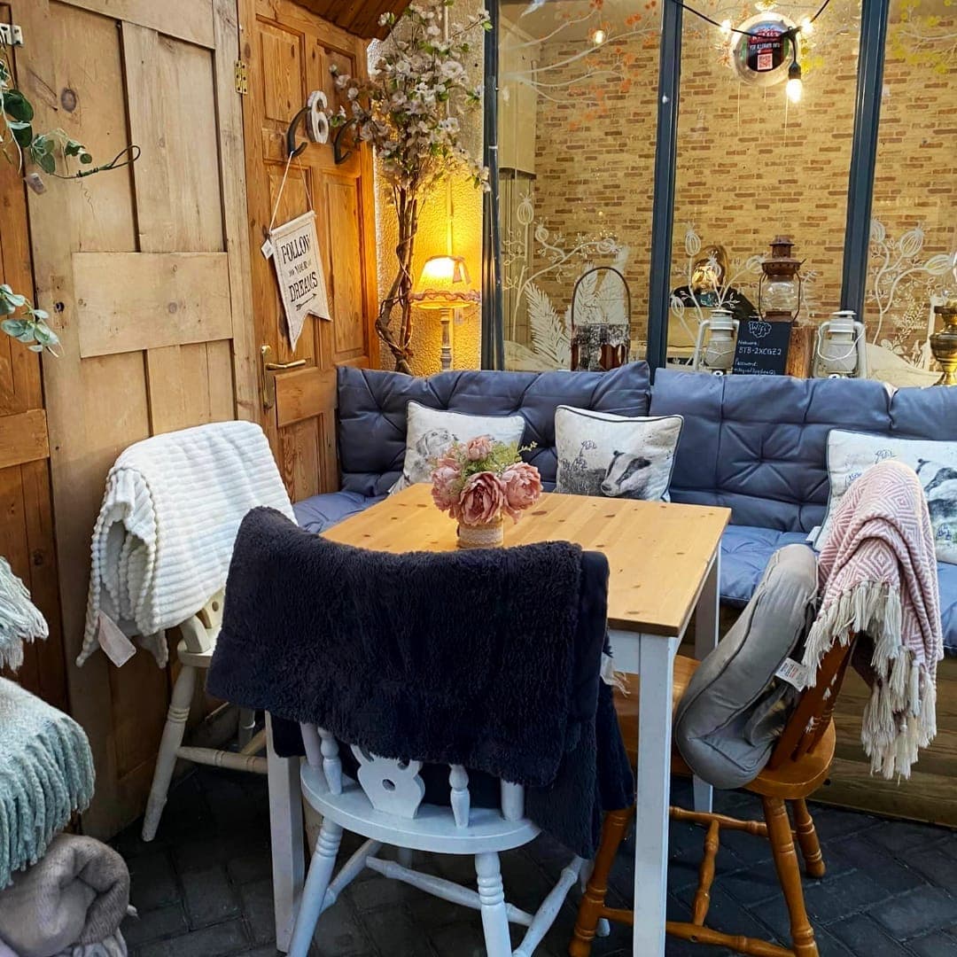 Intimate cafe seating area with blue cushioned sofas, fairy lights and decorative pillows at Miracle cafe