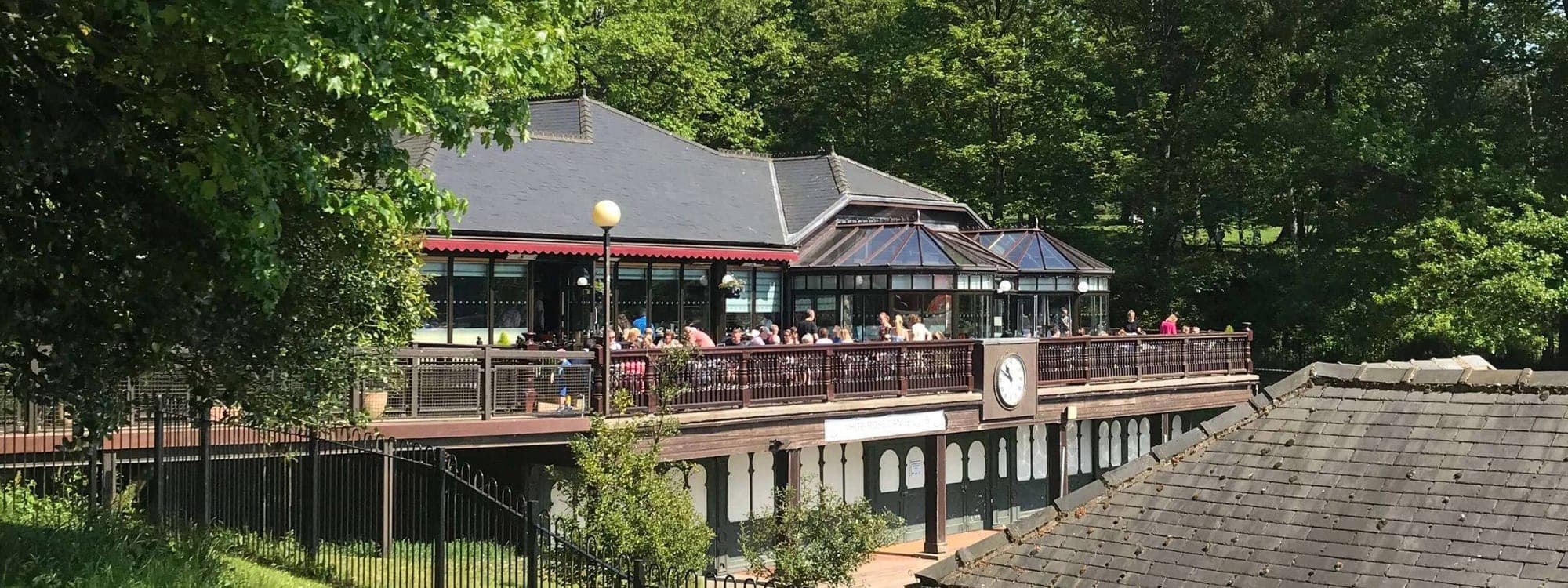 Exterior view of The Lakeside Cafe nestled among trees in Roundhay Park on a sunny day