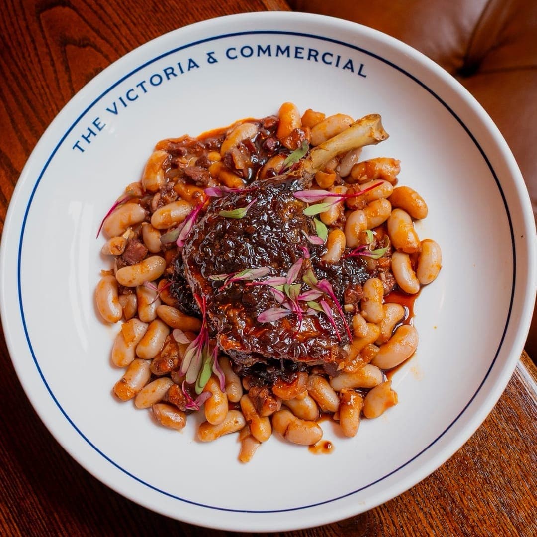 Confit duck leg with rich cassoulet of white beans on a branded Victoria and Commercial plate
