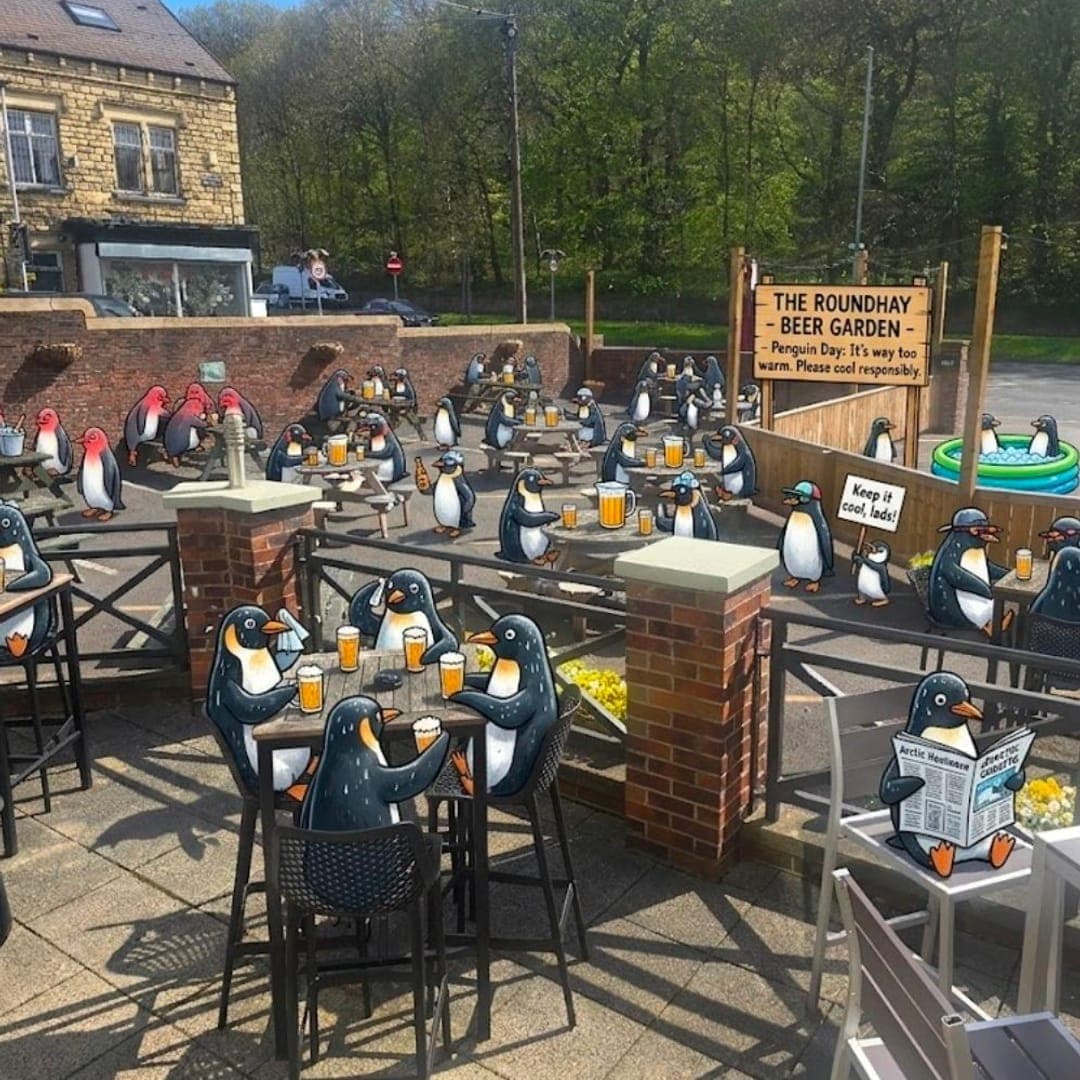 The Roundhay beer garden filled with penguin decorations on a sunny day with outdoor seating