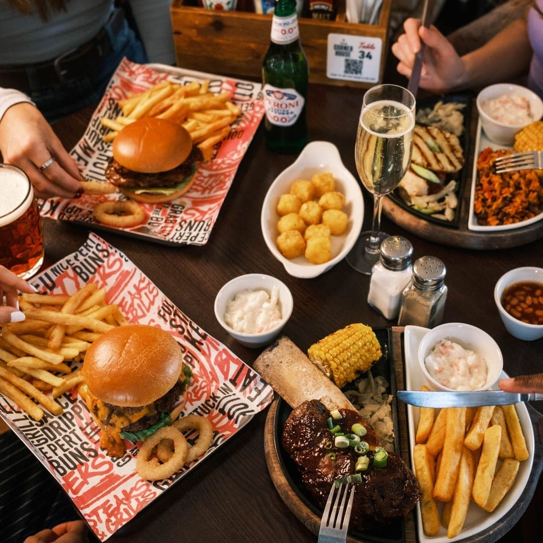 Plate of fish and chips alongside a burger at The Roundhay pub in Leeds
