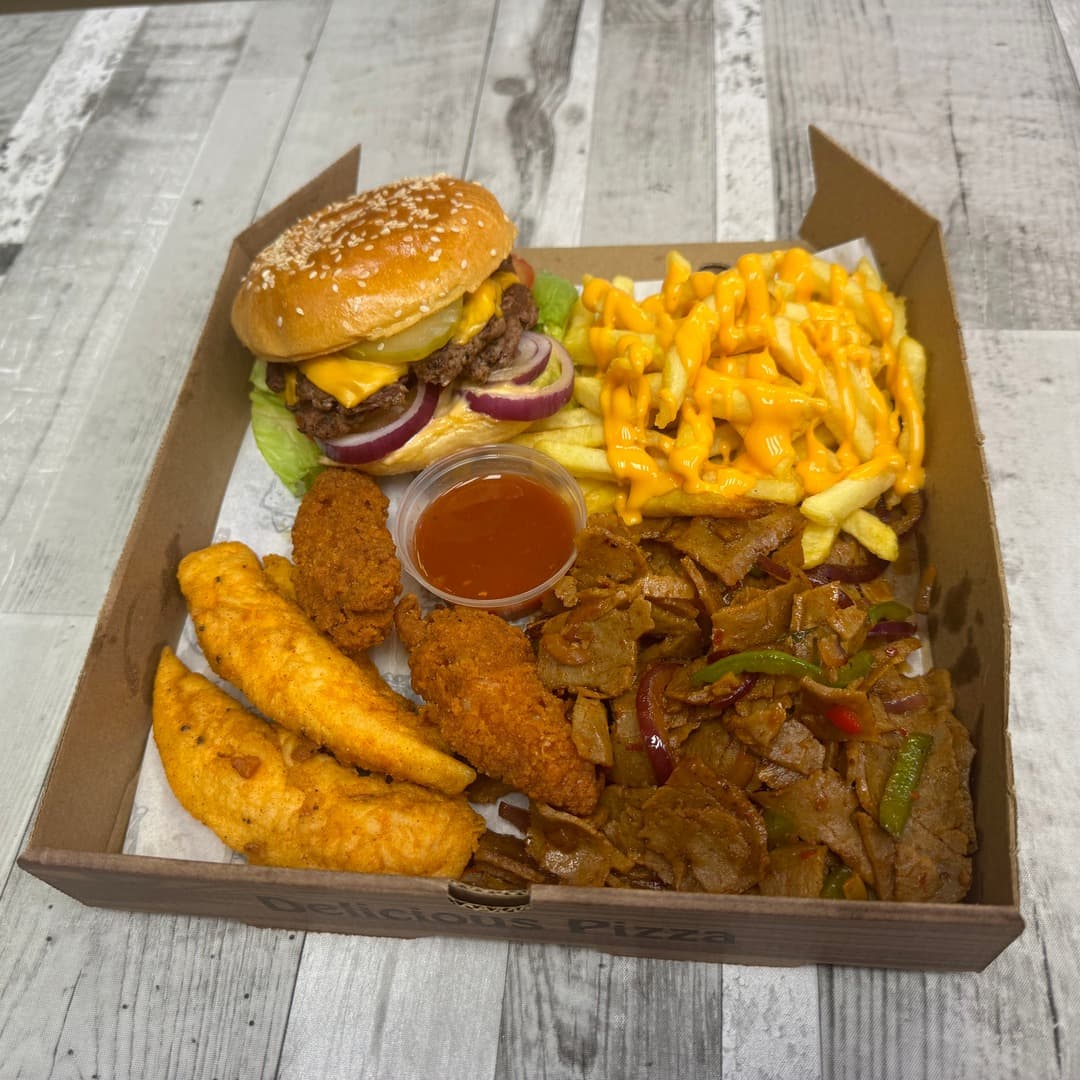 A takeaway meal box from Smash Down Leeds with a smash burger, cheesy fries, breaded chicken pieces and donner kebab strips with peppers, served with a chilli sauce dip.