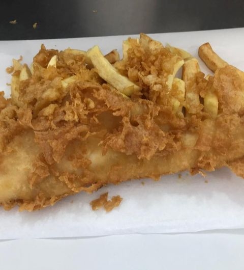 Ideal Fisheries Fresh Fish and Chips Delicious Golden-battered fish and chips on a white paper, a classic dish from Ideal Fisheries.