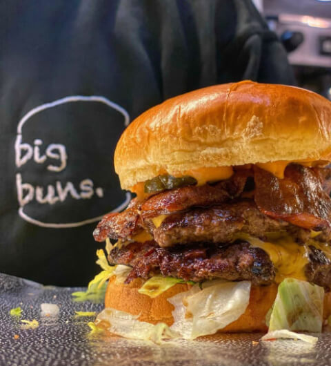 Big Buns burger with branded tshirt in background Big Buns Leeds burger with branded tshirt in background