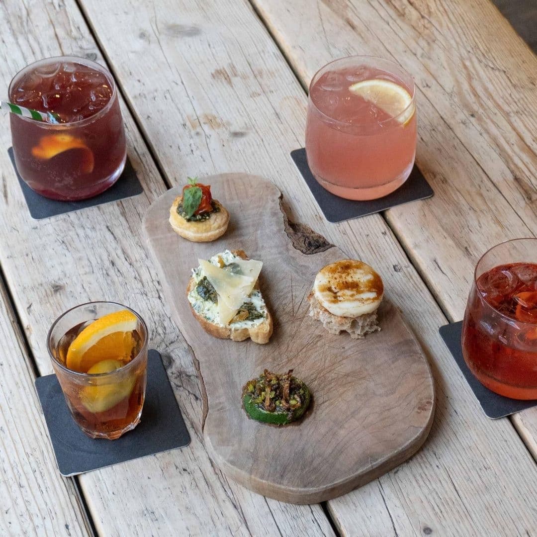 Friends of Ham Leeds City Craft Cocktails Charcuterie Board Assorted gourmet appetizers and cocktails on a wooden serving board at Friends of Ham – Leeds City.